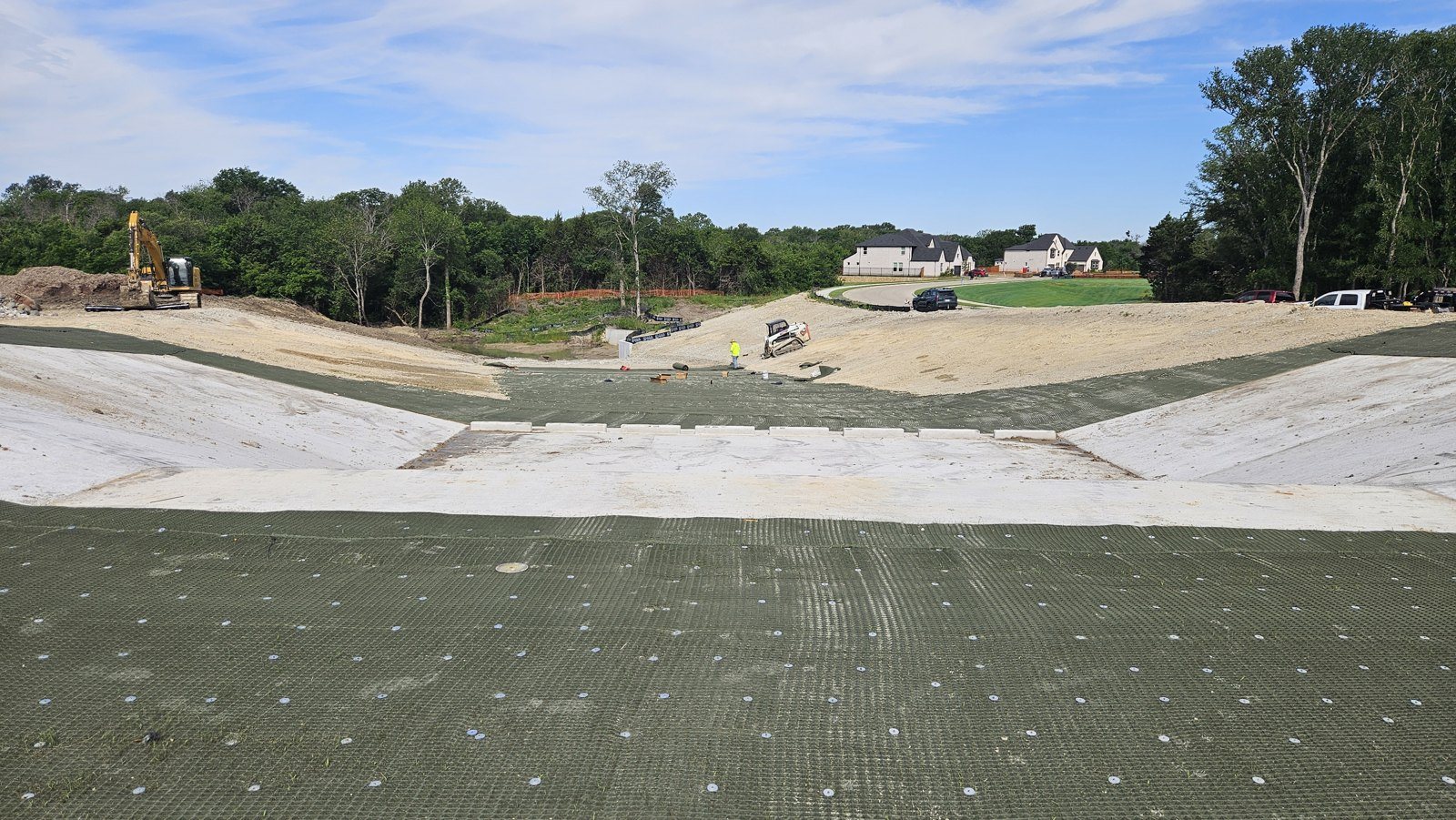 Anchored high-performance turf reinforcement mat pinned across a graded channel