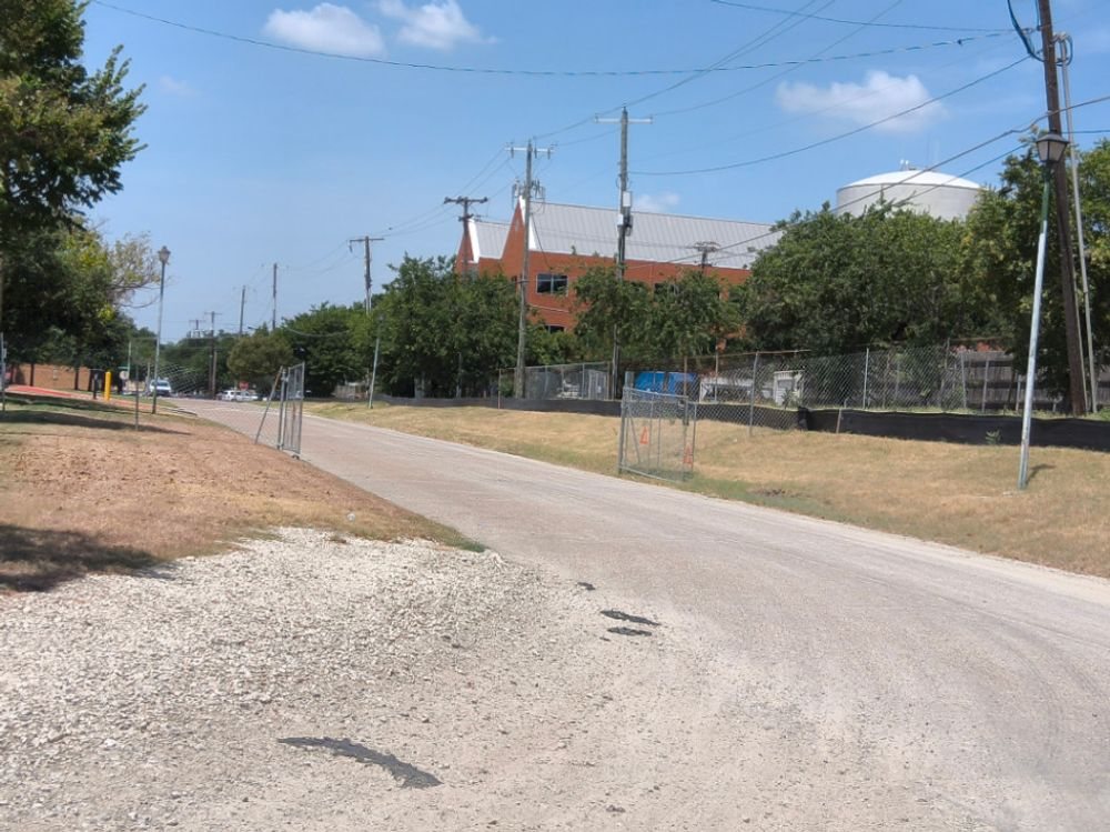 Rock construction entrance and perimeter fencing at a Dallas service center site