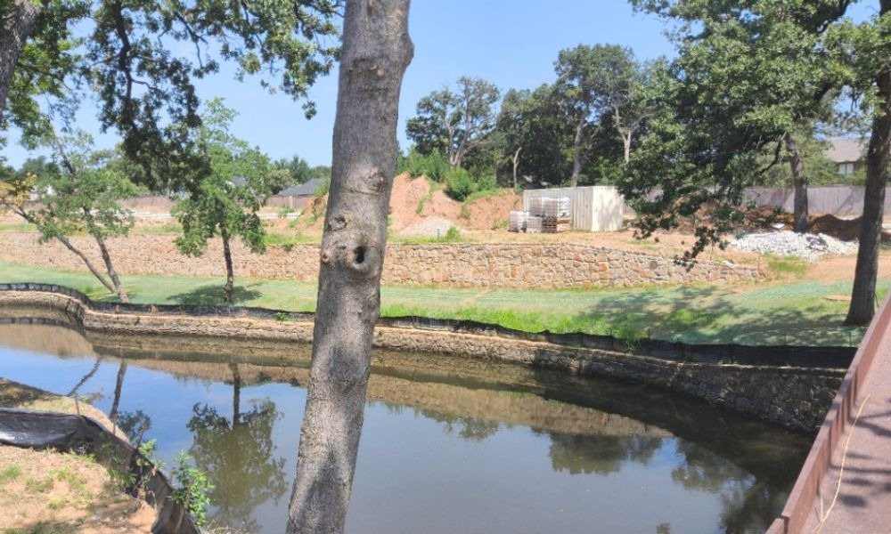 Silt fence and a stone retaining wall protecting a pond on a Grapevine site
