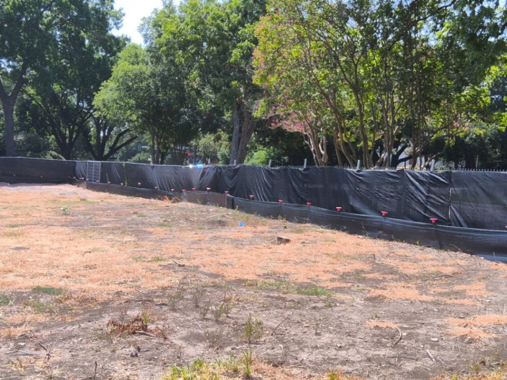 Silt fence with capped T-posts along a cleared Highland Park lot