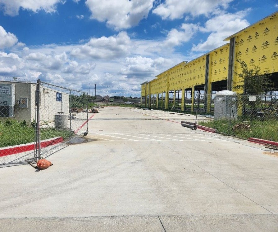Paved construction exit at a Lewisville commercial build under framing