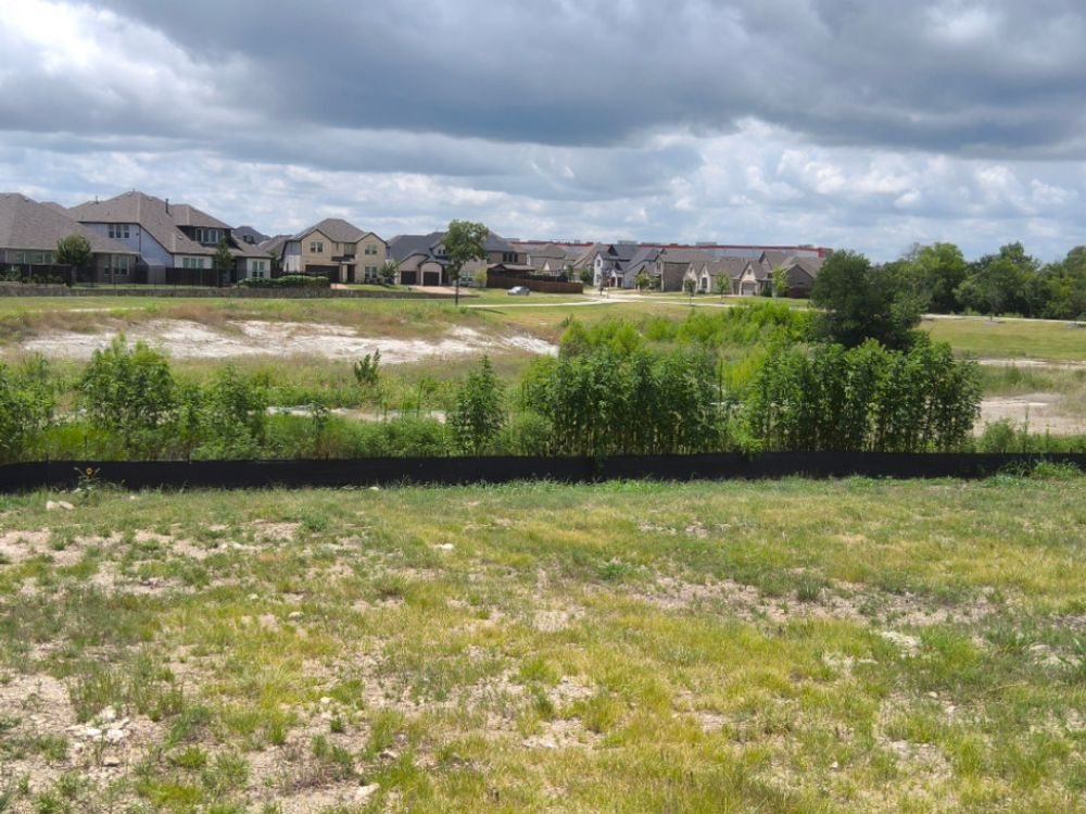 Perimeter silt fence running across a Melissa residential development