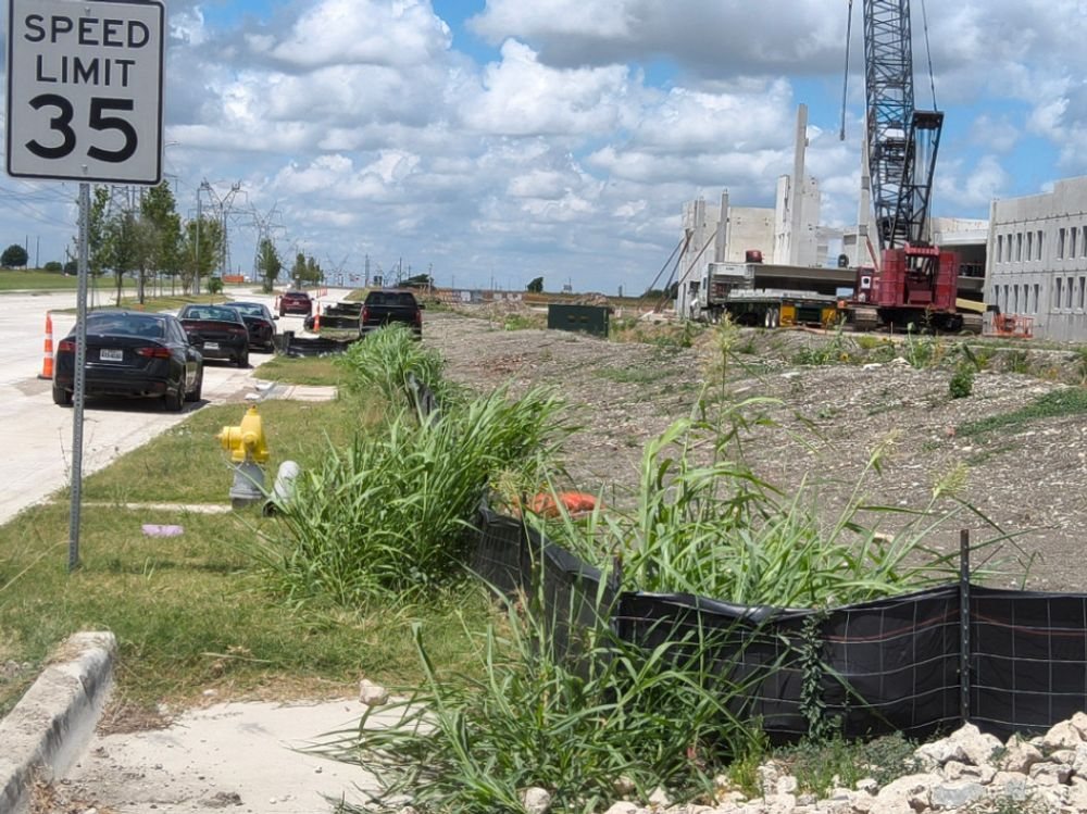 Silt fence along the street frontage of a Plano multifamily build