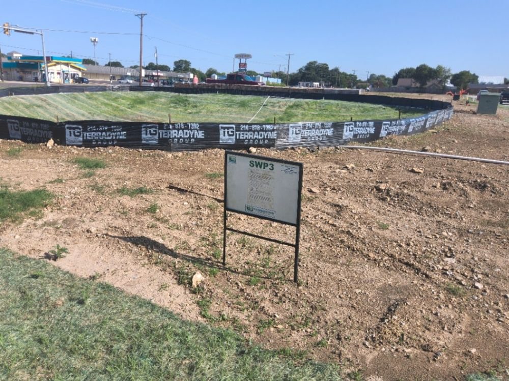 An SWP3 site notice posted beside Terradyne branded silt fence on a Tarrant County site