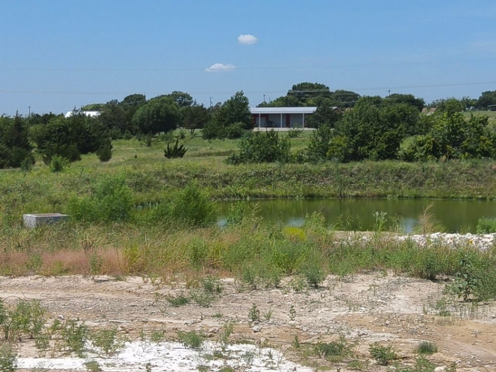 A stabilized detention basin and its outlet structure on a Grayson County construction site