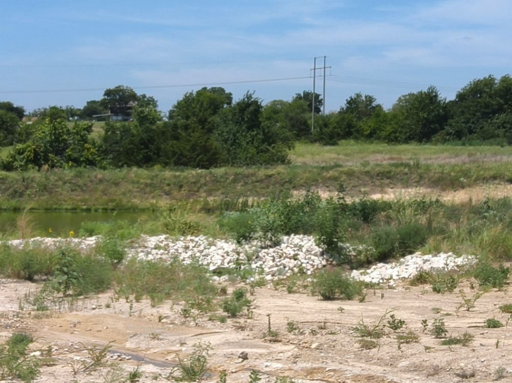 Rock outfall protection at a detention pond on open Grayson County construction ground