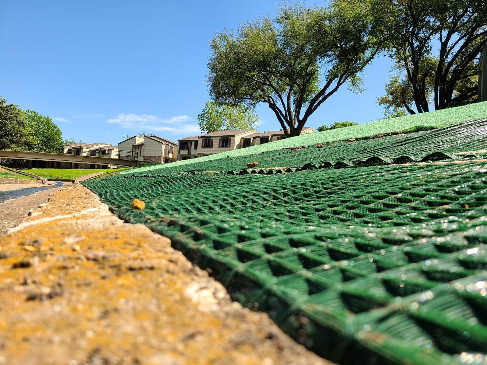 Erosion control mats anchored along a channel beside a city street